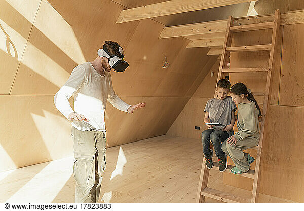 Man with 3d glasses and kids visualising home interior at new eco house