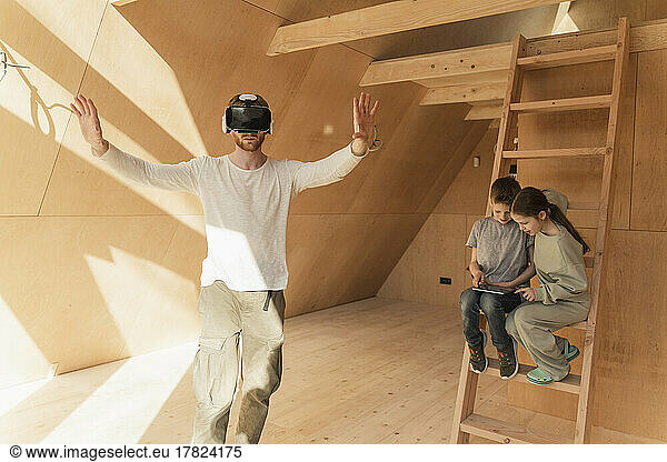 Man with 3d glasses and kids visualising home interior at new eco house
