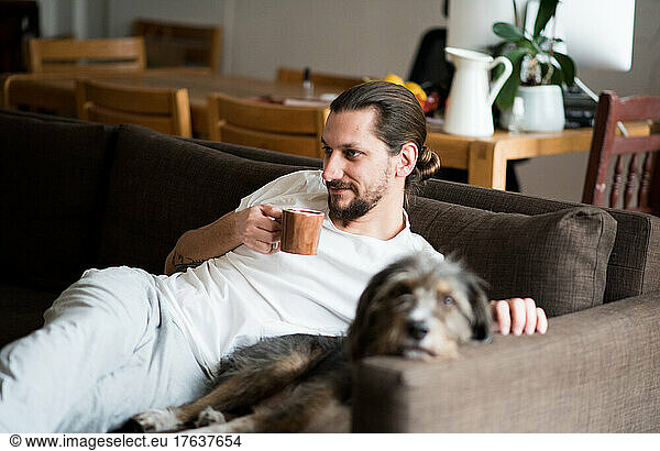 Man with dachshund relaxing on sofa