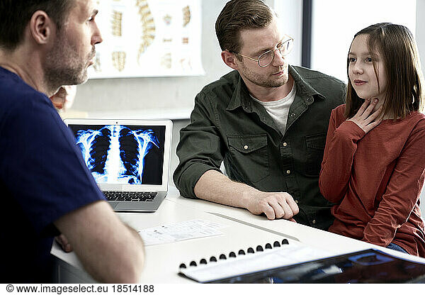 Man with daughter explaining doctor in medical clinic