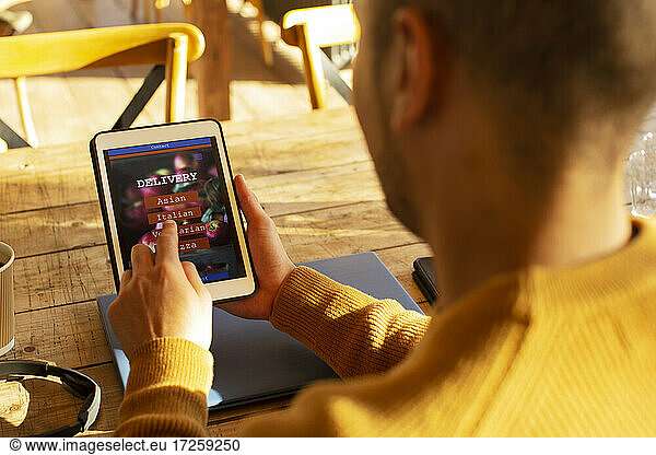 Man with digital tablet ordering food by app on digital tablet