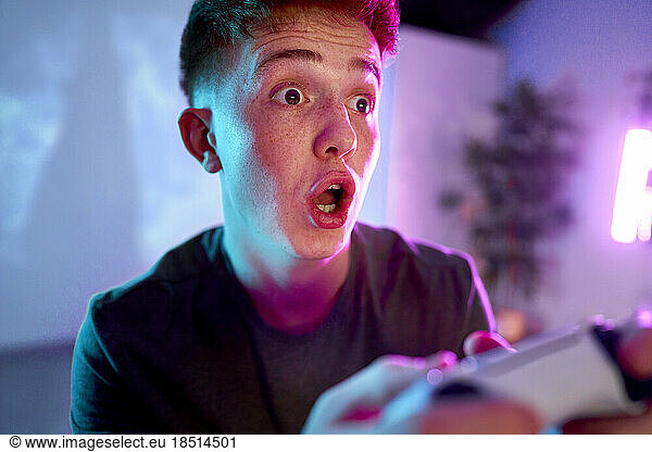 Man with facial expression playing leisure game at home