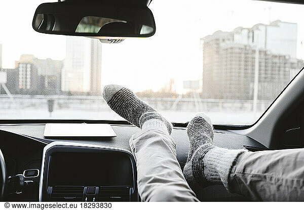 Man with feet on dashboard in car