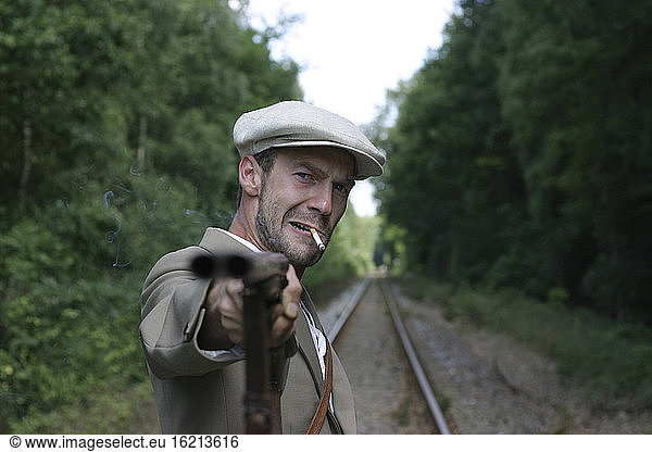 man with gun on the railroad