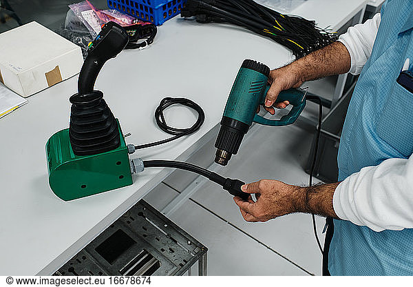 man with hot air gun repairing a key of a remote control