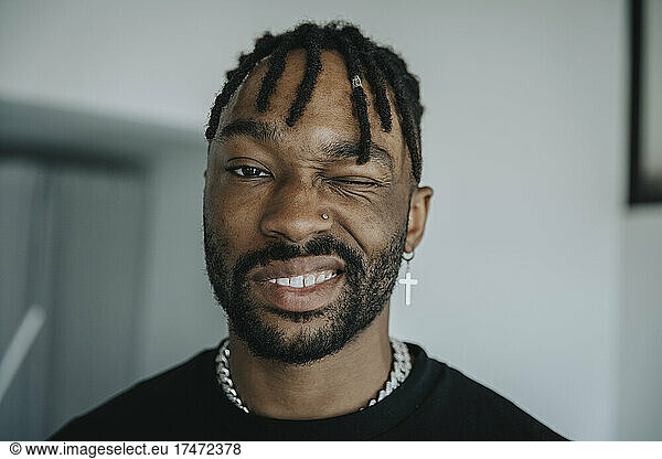 Man with locs winking