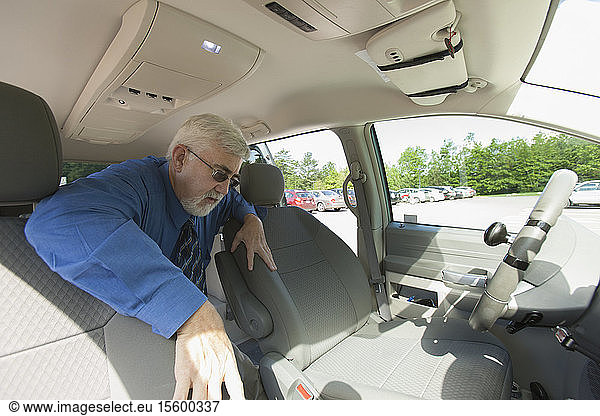 Man with muscular dystrophy and diabetes getting into the front seat of an accessible van