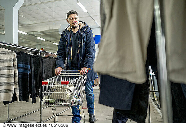 Man with shopping cart looking at clothes