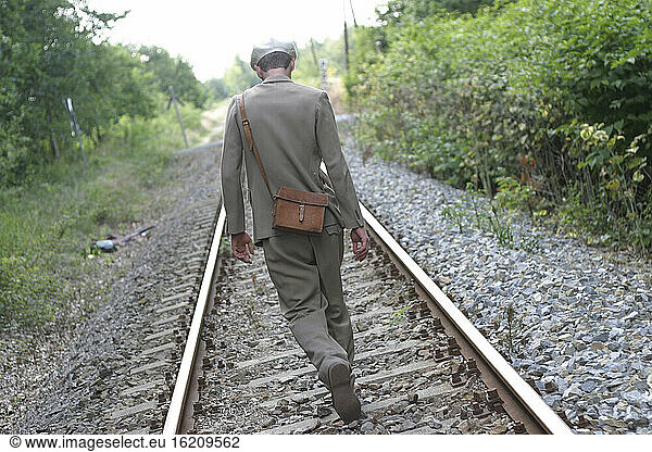 man with shoulderbag on the railroad