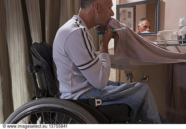 Man with spinal cord injury in a wheelchair brushing his teeth