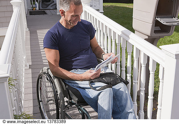 Man with spinal cord injury in a wheelchair getting his mails