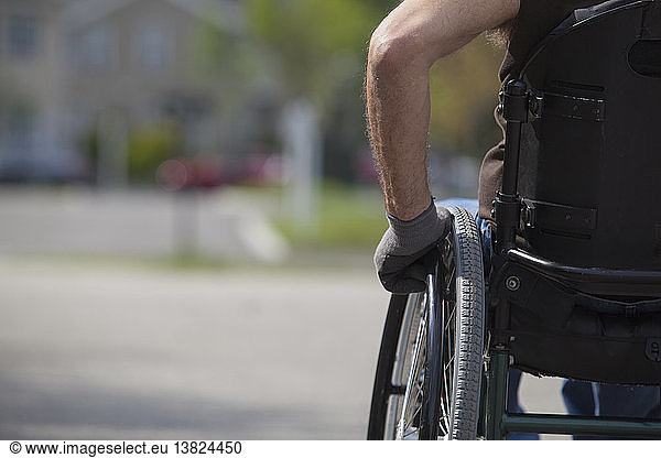 Man with spinal cord injury in a wheelchair on street corner
