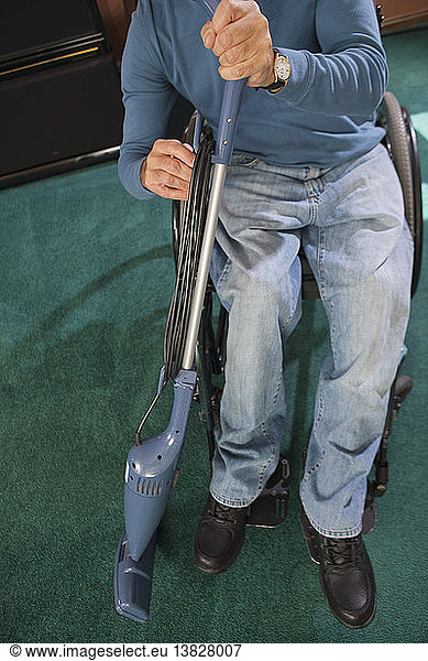 Man with spinal cord injury in a wheelchair rewinding power cord on vacuum cleaner