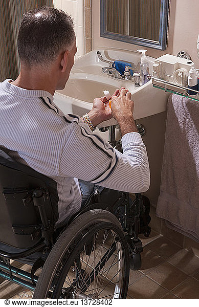 Man with spinal cord injury in a wheelchair taking medicines