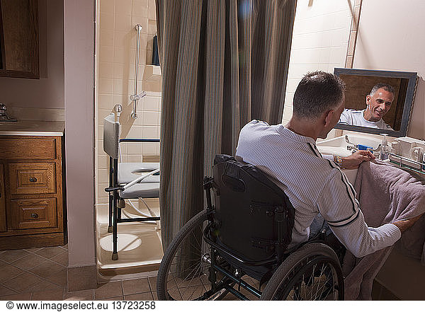 Man with spinal cord injury in a wheelchair using a towel