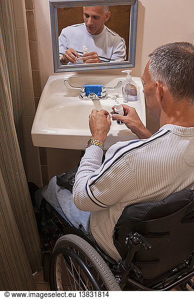 Man with spinal cord injury in an accessible bathroom putting in contact lenses
