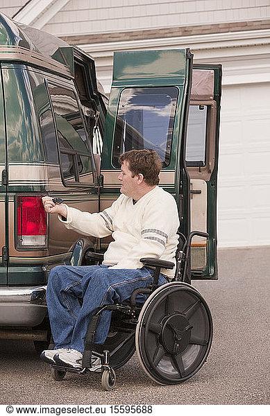 Man with spinal cord injury using magnetized remote to close his accessible vehicle