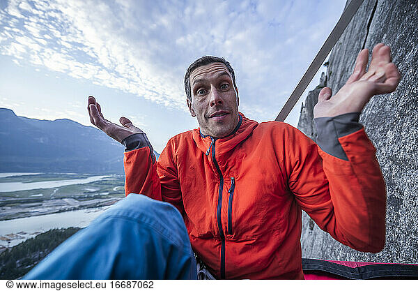 Man with surprised look showing interrogation on portaledge at sunset