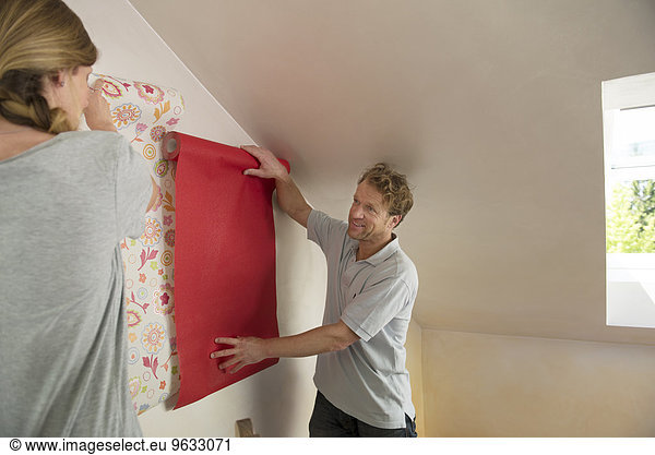 Man woman selecting wallpaper decorating