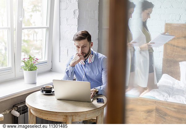 Man working at laptop in apartment
