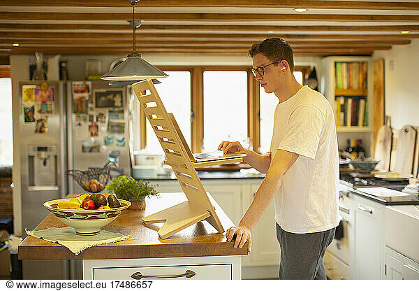 Man working at laptop standing desk in kitchen