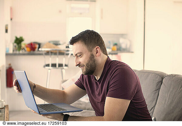 Man working from home at laptop on sofa