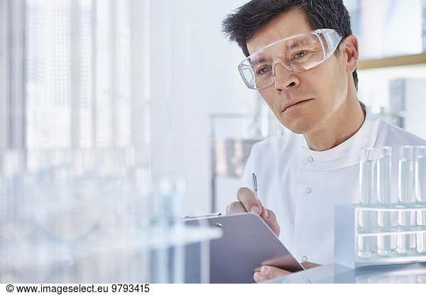 Man working in laboratory holding chart
