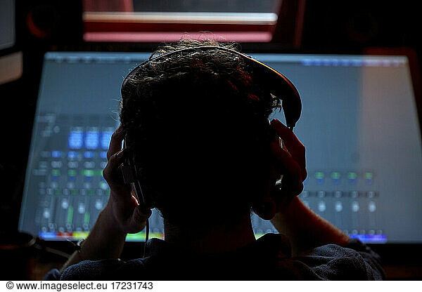Man working in music studio  using large computer screen