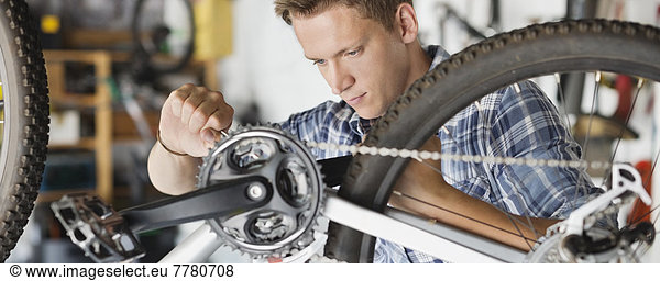 Man working on bicycle in shop