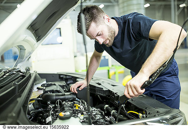 Man working on car in modern factory