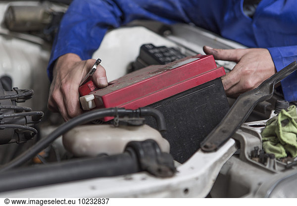Man working on car removing battery