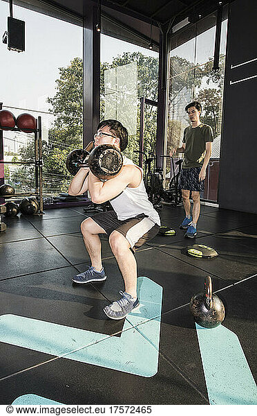 man working out with kettlebells at gym in Bangkok