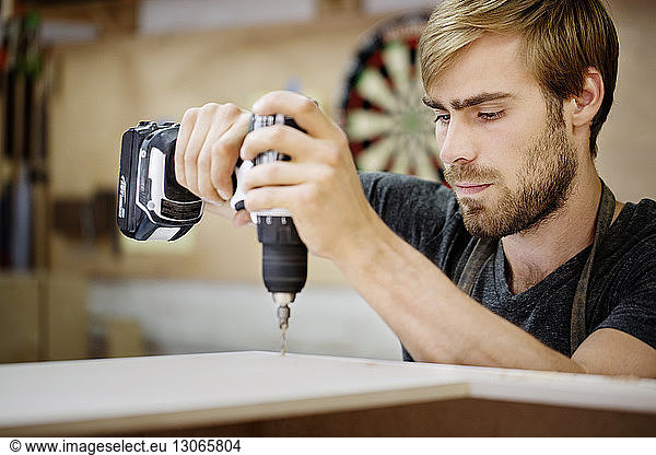 Man working with drill machine in workshop