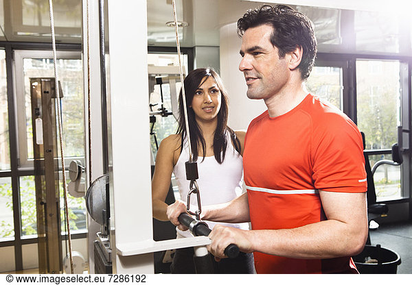 Man working with trainer at gym