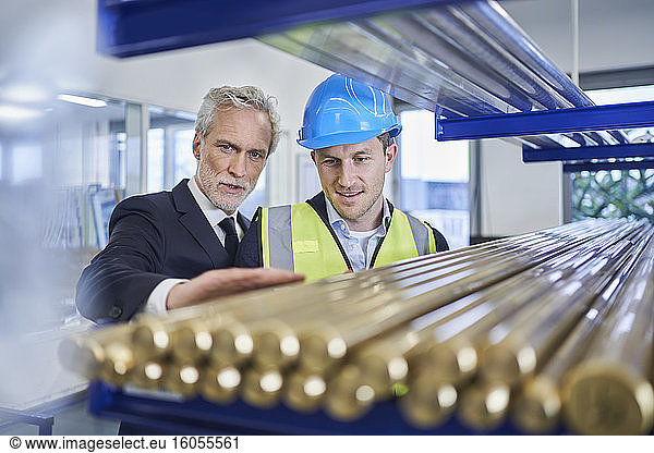 Manager bespricht Metallrohre mit Vorarbeiter in der Fabrik