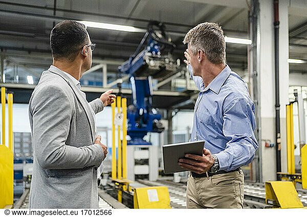 Manager und Vorgesetzter diskutieren über Maschinen in der Fabrik
