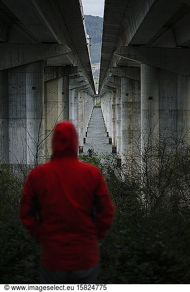 Mann an einer Autobahnbrücke in verlassener Umgebung