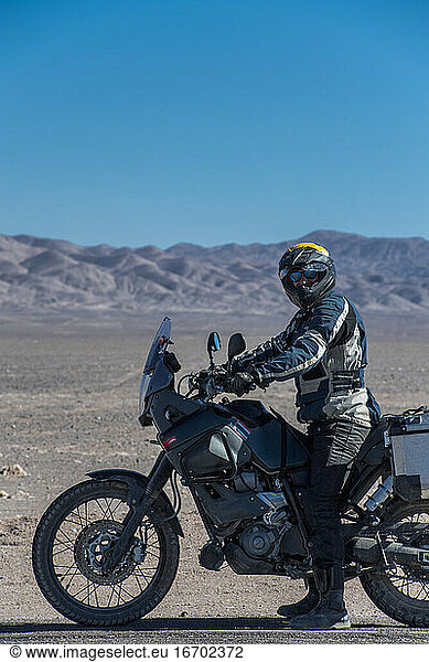 Mann auf Reisemotorrad in der Atacama-Wüste