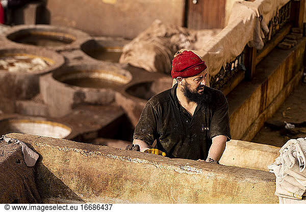 Mann bei der Arbeit in einer Ledergerberei in Fez  Marokko
