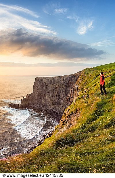 Mann bei Sonnenuntergang an den Cliffs of Moher  Grafschaft Clare  Provinz Munster  Republik Irland  Europa.