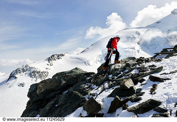 Mann besteigt schneebedeckten Berg  Saas Fee  Schweiz