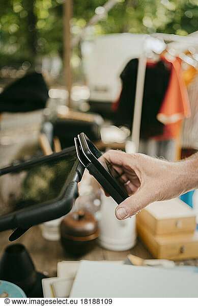 Mann bezahlt mit digitaler Brieftasche beim Einkaufen auf dem Flohmarkt