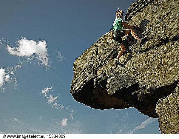 Mann bouldert auf Gittersteinen im Peak District / UK