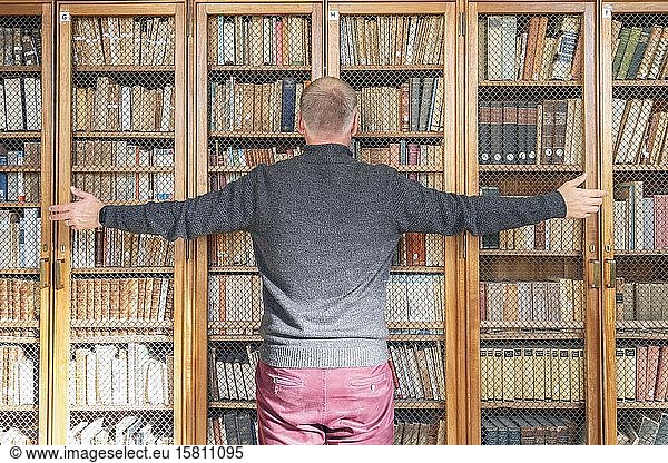 Mann  der versucht  das Wissen aus den Büchern im Bücherregal zu holen  Portugal  Europa