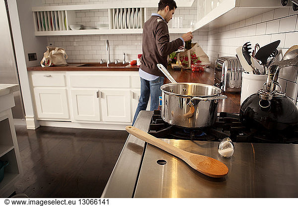 Mann entfernt Lebensmittel aus Einkaufstasche in Küche