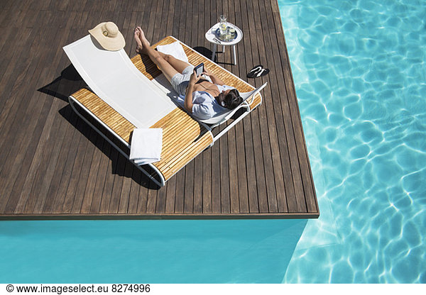 Mann entspannt sich auf Liegestuhl am Pool