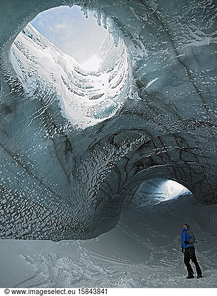 Mann erforscht Eishöhle in Island