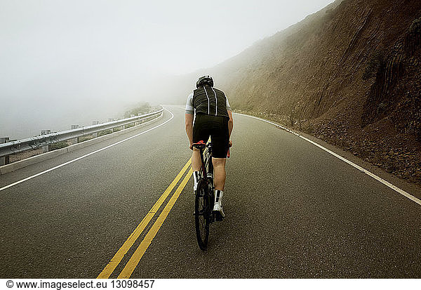 Mann fährt bei nebligem Wetter auf Bergstraßen