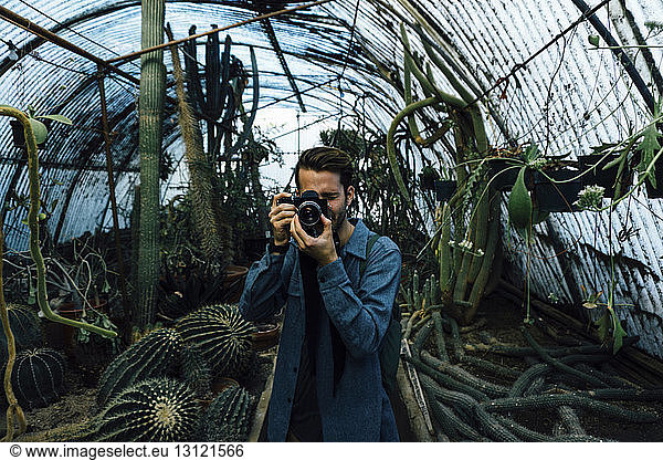 Mann fotografiert im Kaktus-Gewächshaus