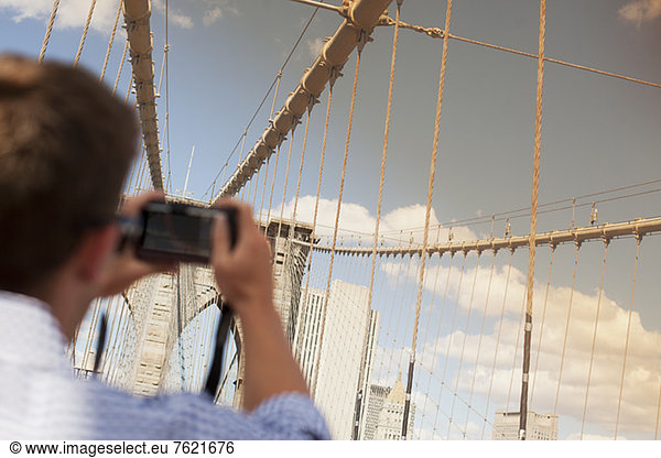 Mann fotografiert Stadtbrücke